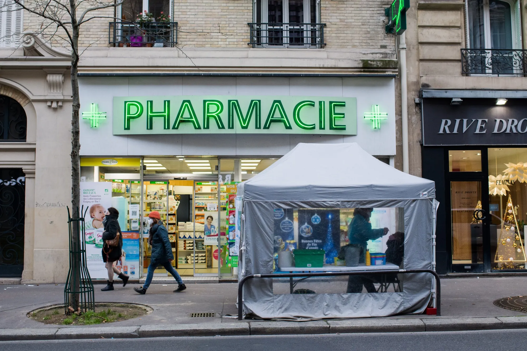 A member of the public receives a nasal swab from a health worker at a Covid-19 testing tent set up outside a pharmacy in Paris, France.