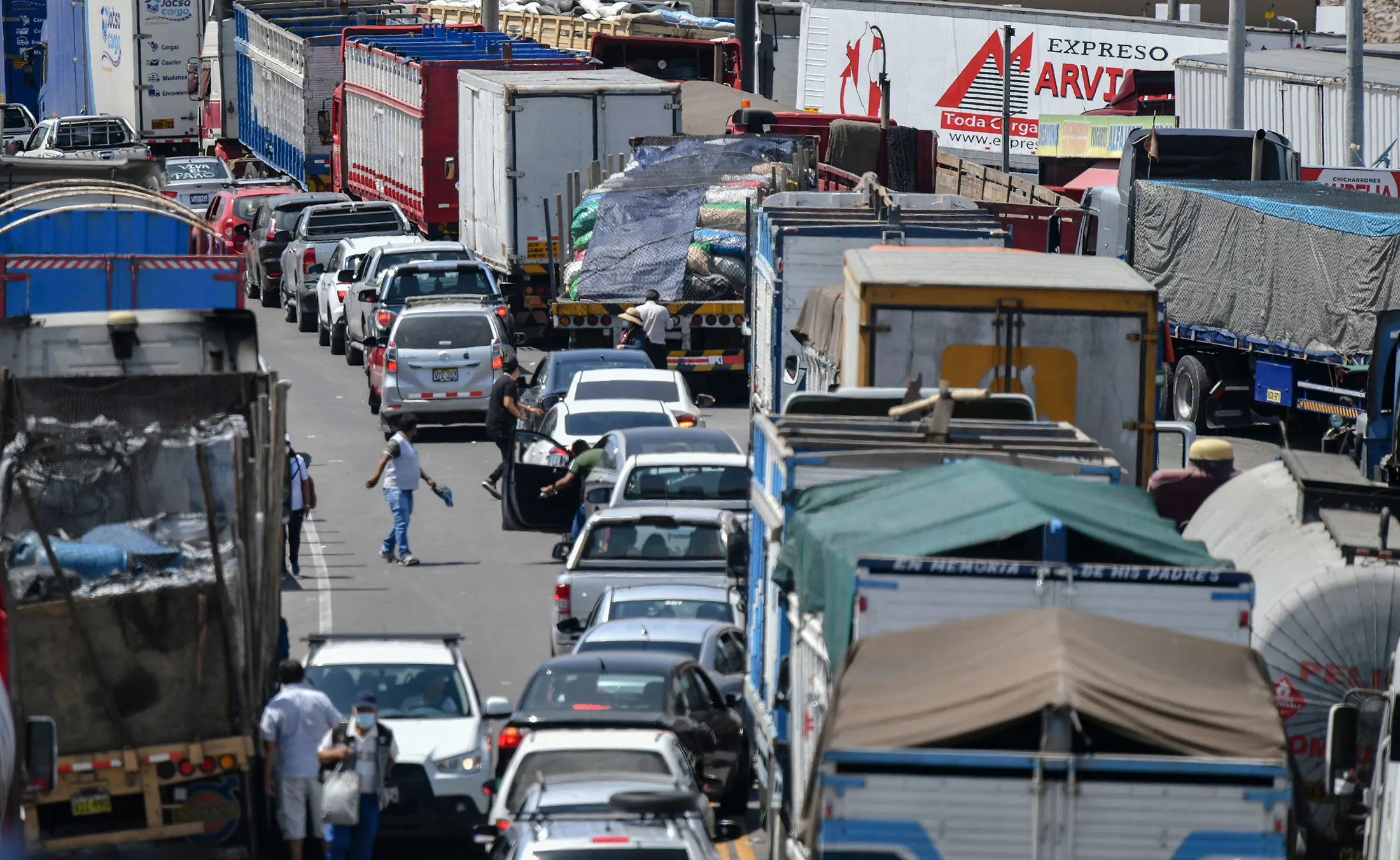 People walk along a stretch of the Panamerican Highway blocked by truck drivers demanding nationwide lower fuel costs and reduced toll payments, near&nbsp;Arequipa, Peru on March 28.