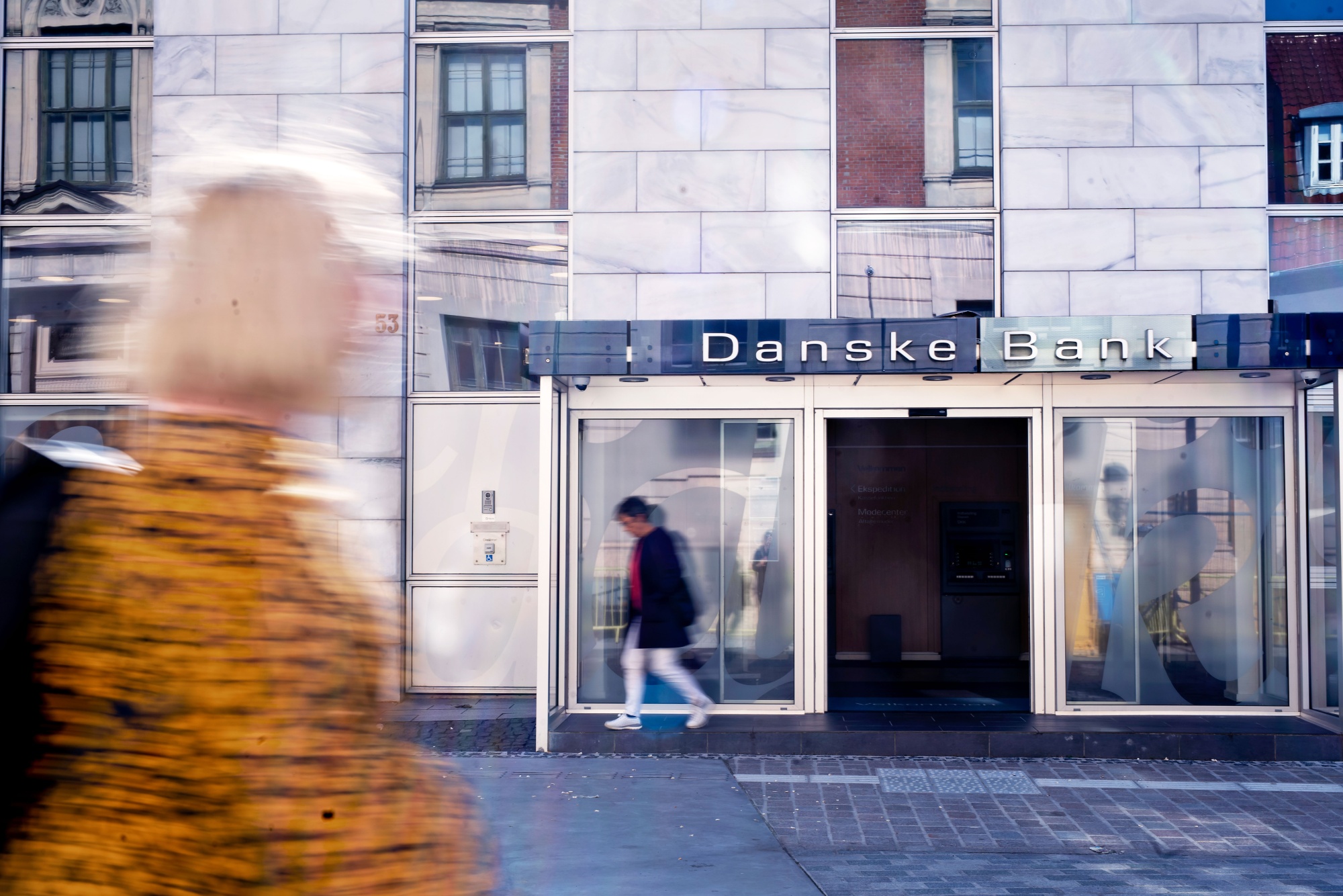 Pedestrians pass a Danske Bank A/S bank branch in Aalborg, Denmark.