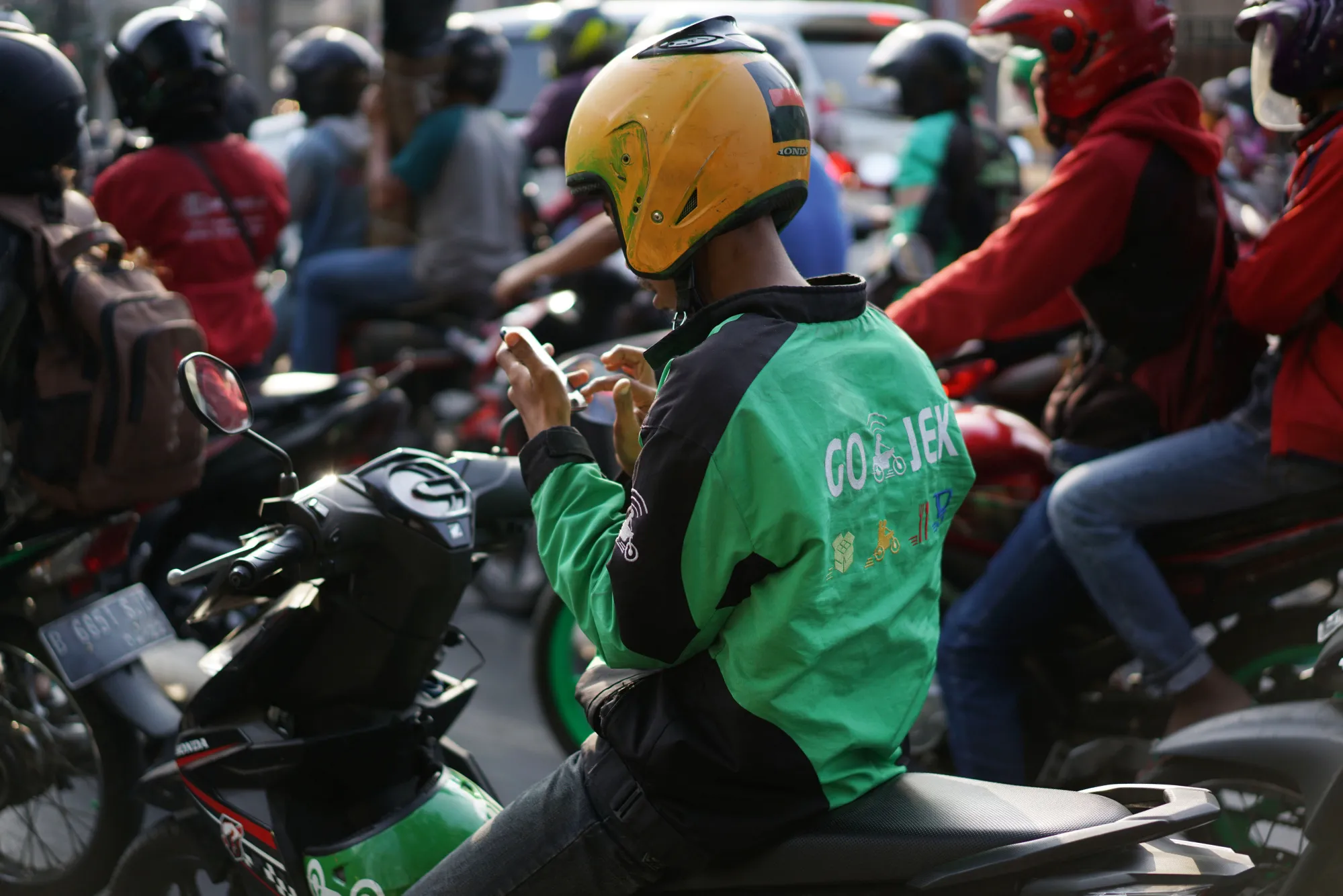 A Go-Jek checks his smartphone in Jakarta.