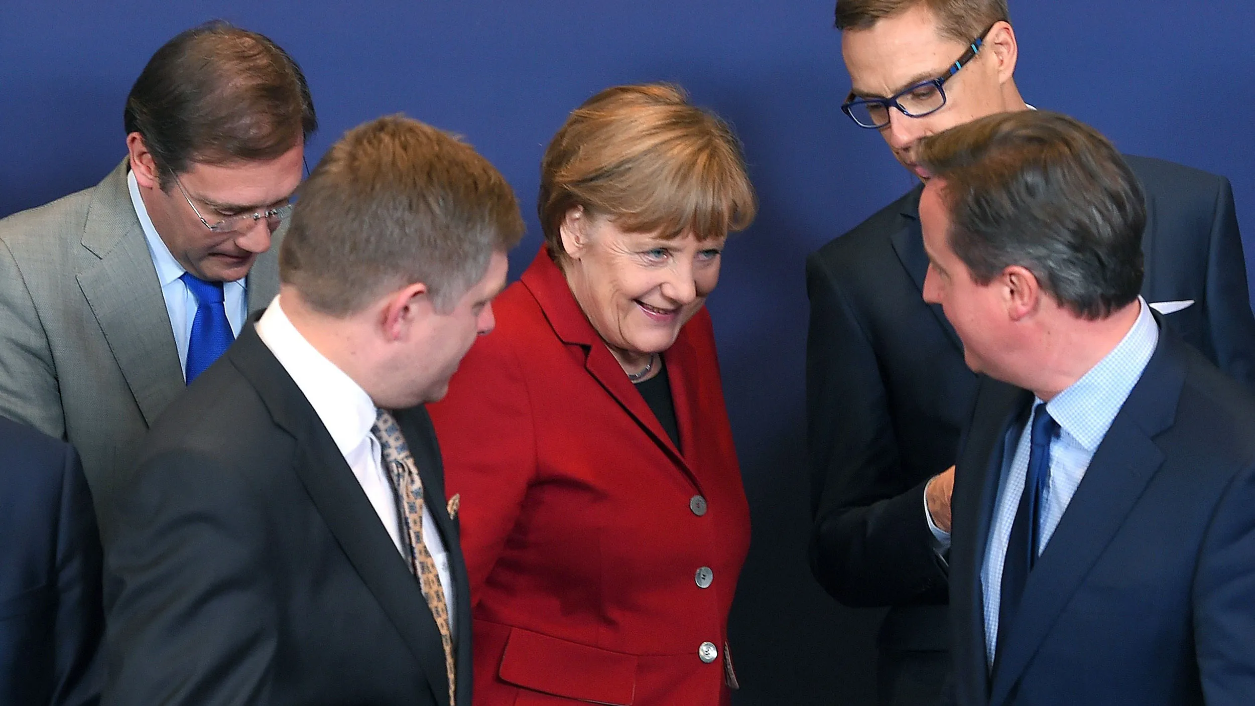 German Chancellor Angela Merkel, center, Portuguese Prime Minister Pedro Passos Coelho, left, Slovak Prime Minister Robert Fico, second left, Finnish Prime Minister Alexander Stubb, second right, and British Prime Minister David Cameron arrive on March 19, 2015 for a family photo at an European Council leaders' summit at the European Council in Brussels.
