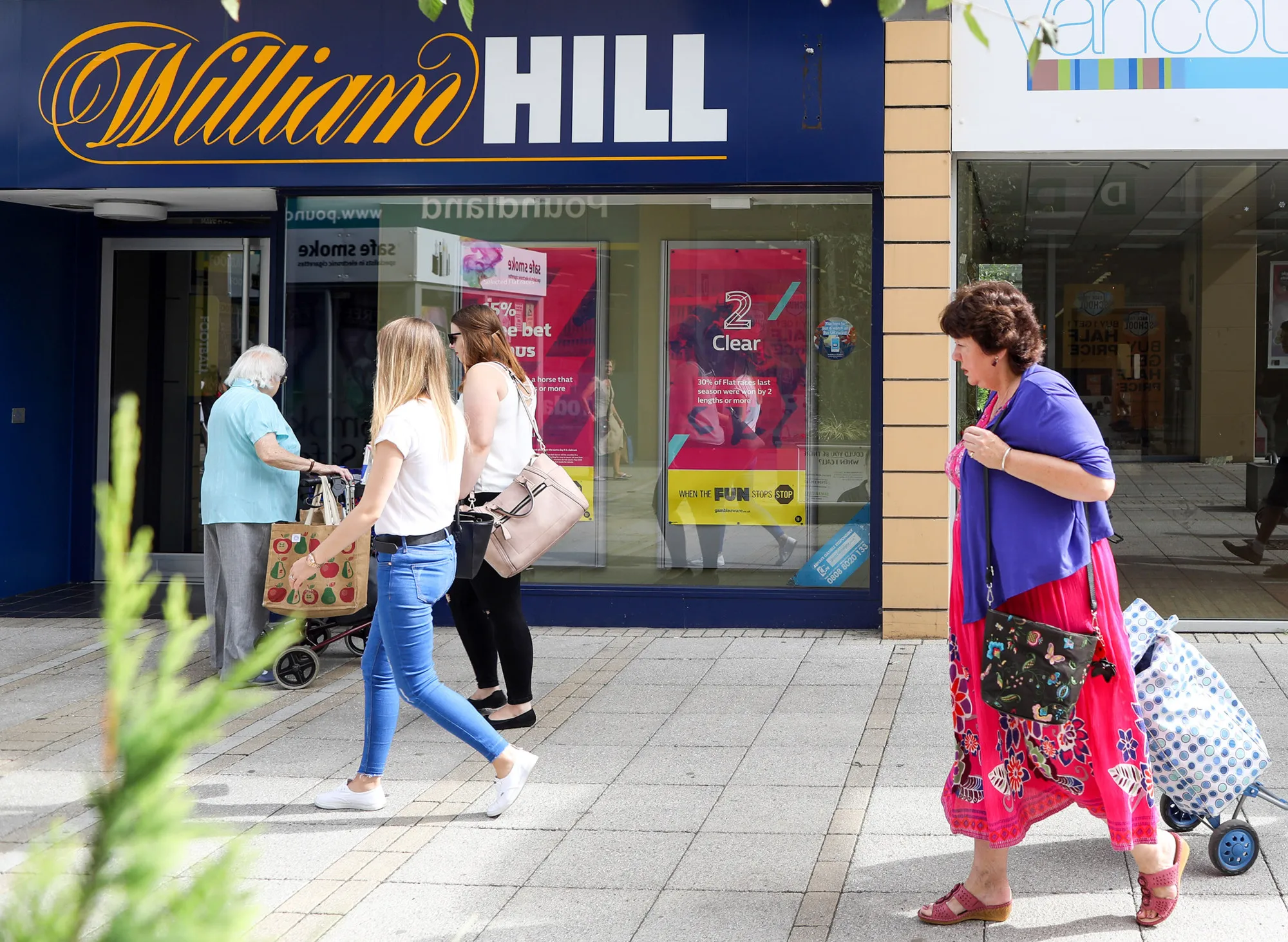 Pedestrians pass a William Hill Plc betting shop in King's Lynn, U.K.