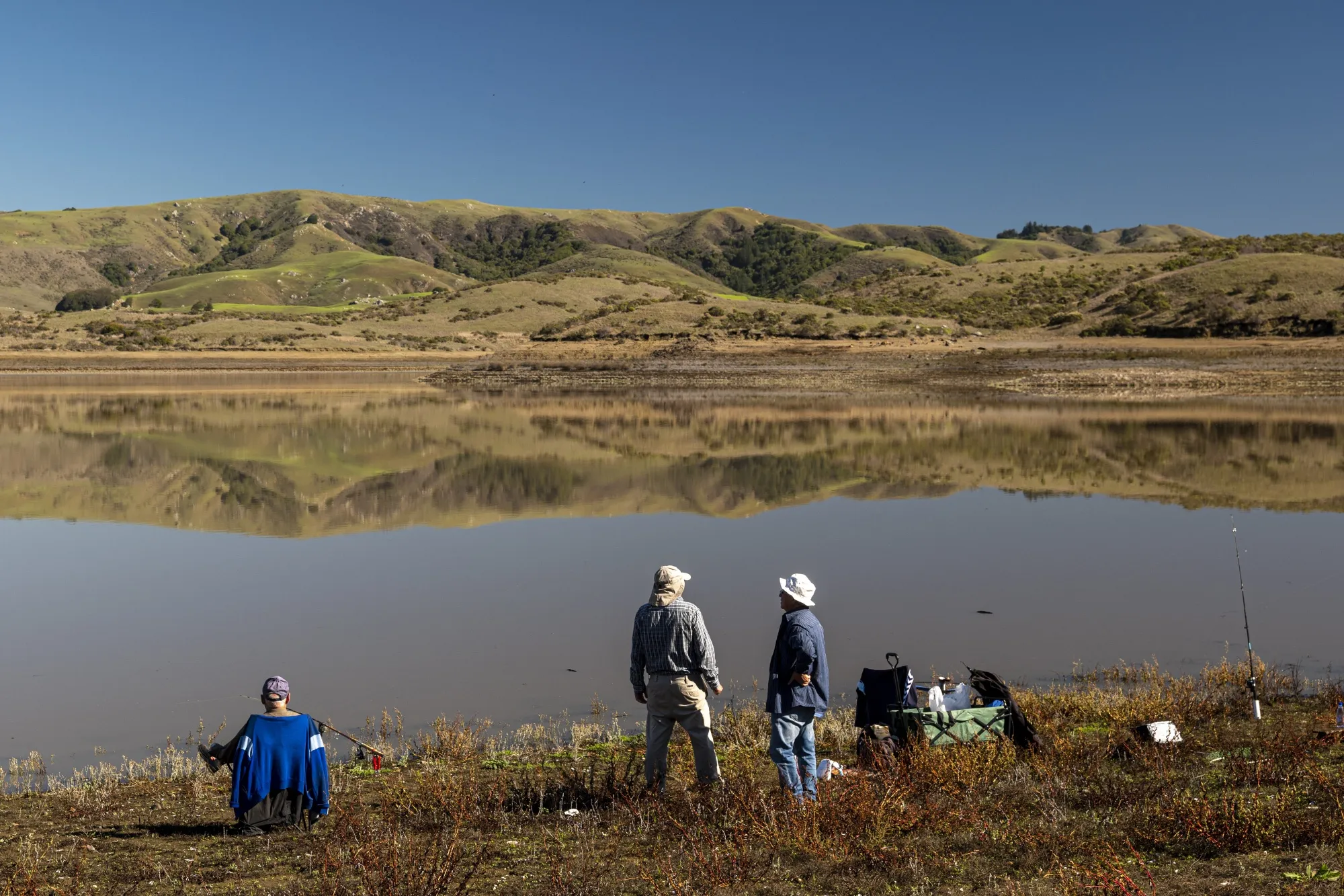 Fishermen along the shore of Nicasio Reservoir after a rainstorm in Nicasio, California, on Nov. 3, 2021.
