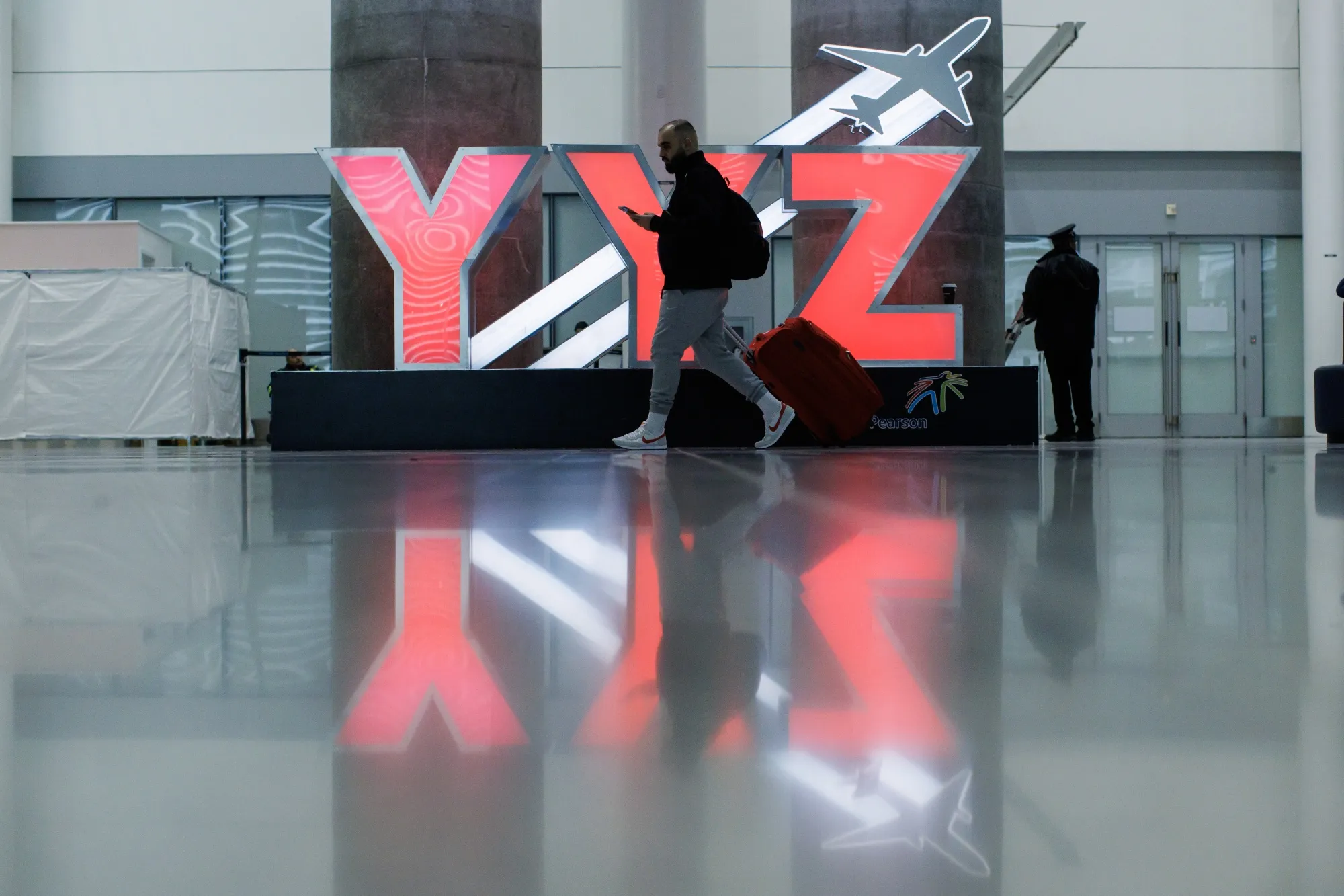 Travelers pass through Pearson International Airport in Toronto earlier this year.