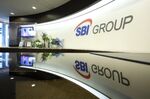 The group logo of SBI Holdings Inc. displayed at a reception area of the company's head office, in Tokyo, Japan, on Tuesday, Oct. 19, 2021. The Bank of Japan and Financial Services Agency are assessing if local financial institutions have any remaining Libor-linked contracts that will be difficult to shift to alternative interest rates before the benchmark expires.