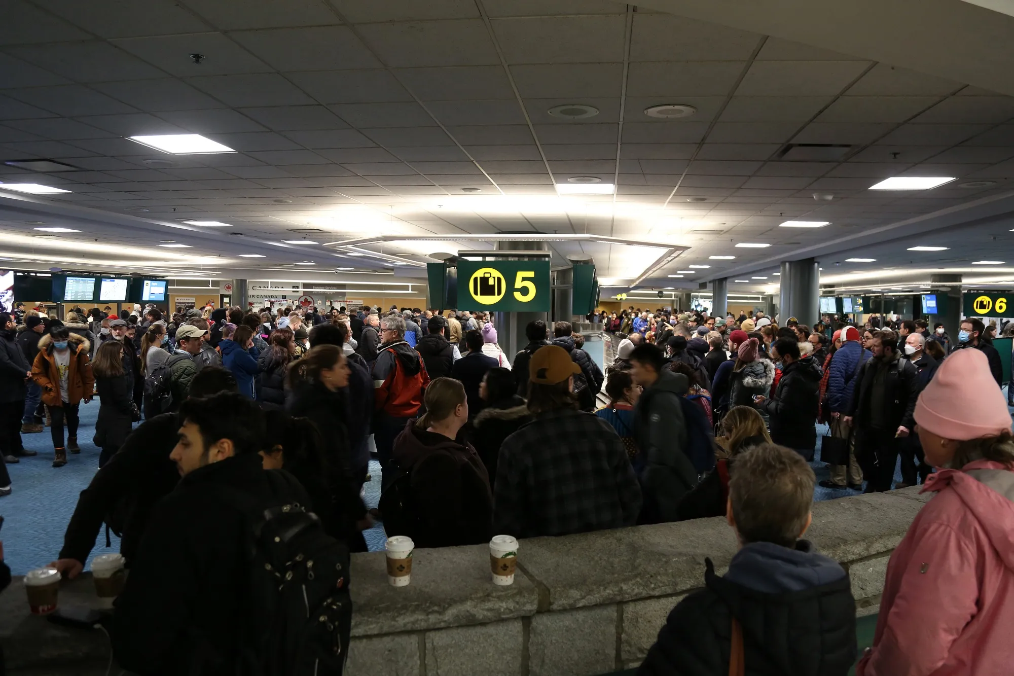 Passengers wait for their bags at Vancouver International Airport on on Dec. 23.