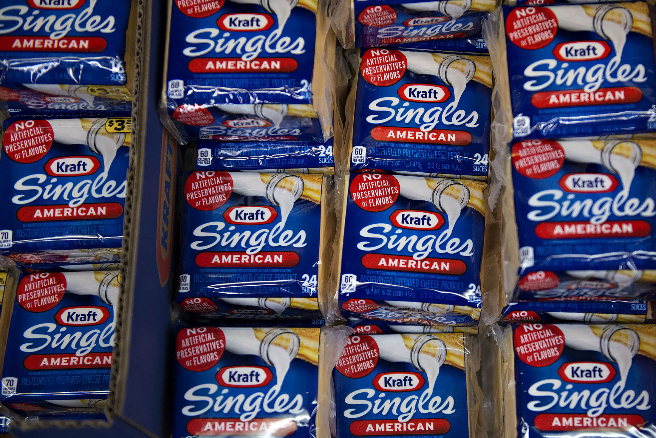 Packages of Kraft Foods Group Inc. sliced American cheese sit on display for sale in a supermarket in Princeton, Illinois, U.S., on Wednesday, July 2, 2014. Rising prices for beef, ice cream and lettuce, mean Americans will spend the most ever for Fourth of July barbecues this year.

