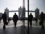 Pedestrians are seen walking through the More London office space against the backdrop of Tower Bridge in London.