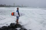 A surfer waits to jump off the rocks at Burleigh Heads in Gold Coast, Australia.