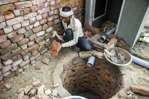 A builder constructs a toilet block in Chapra village, Haryana
