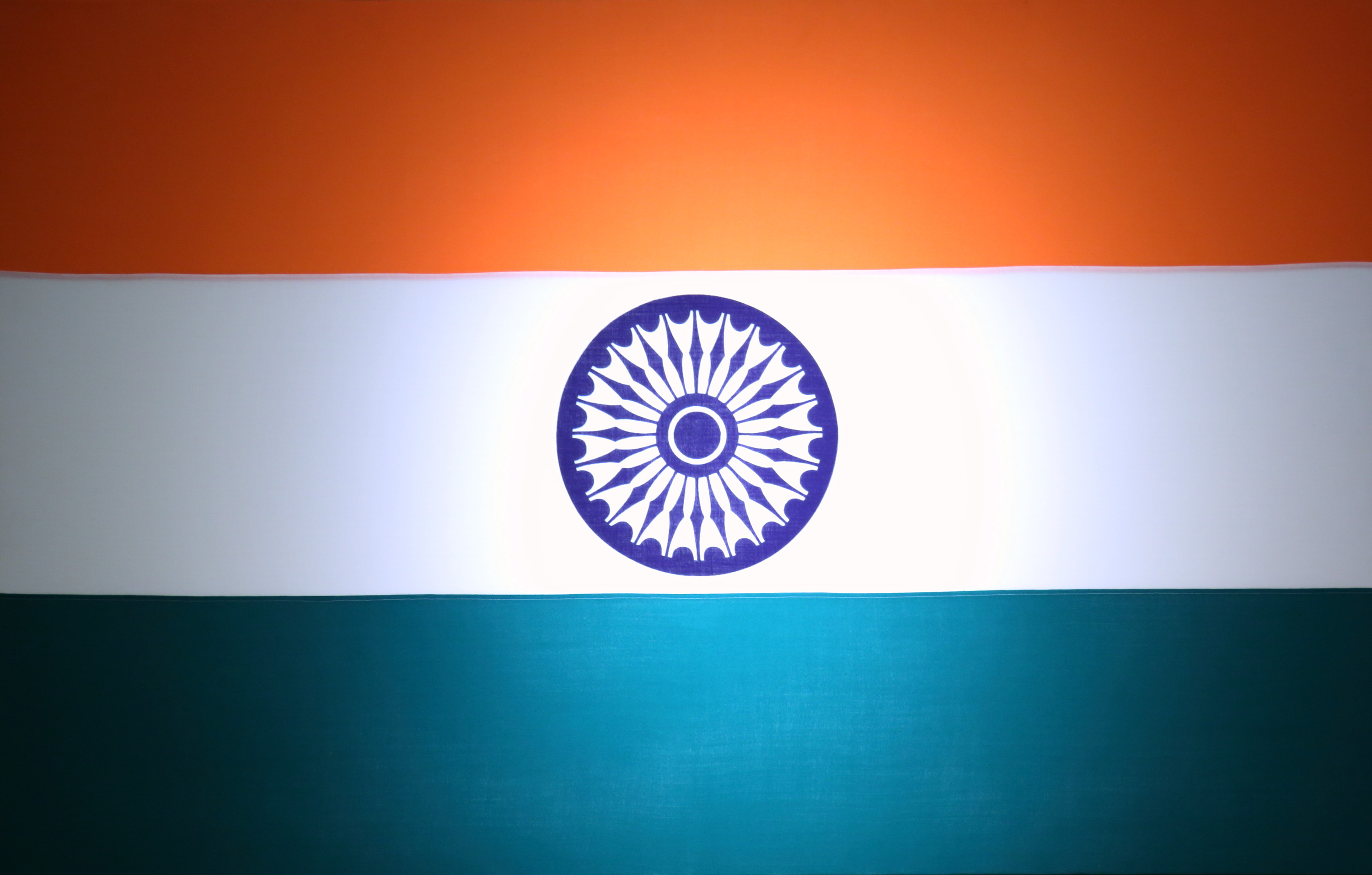 India's national flag is displayed as Manmohan Singh, India's prime minister, unseen, delivers a speech during a meeting in Tokyo, Japan, on Tuesday, May 28, 2013. Singh is in Tokyo on a three-day official visit. Photographer: Tomohiro Ohsumi/Bloomberg