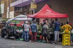 People gather to buy fresh produce from a street vendor in the Central Business District (CBD) of Johannesburg.