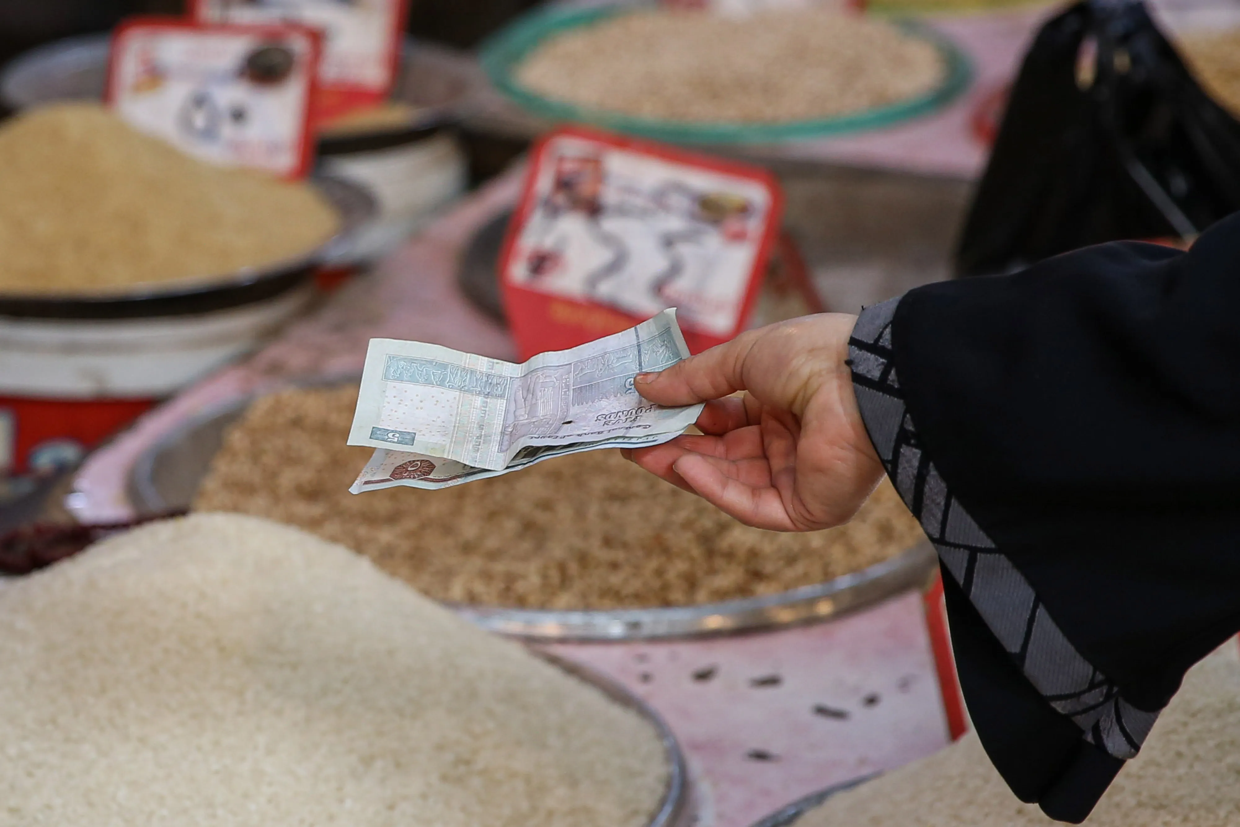 A customer hands over Egyptian pound banknotes for a purchase in Giza, Egypt.