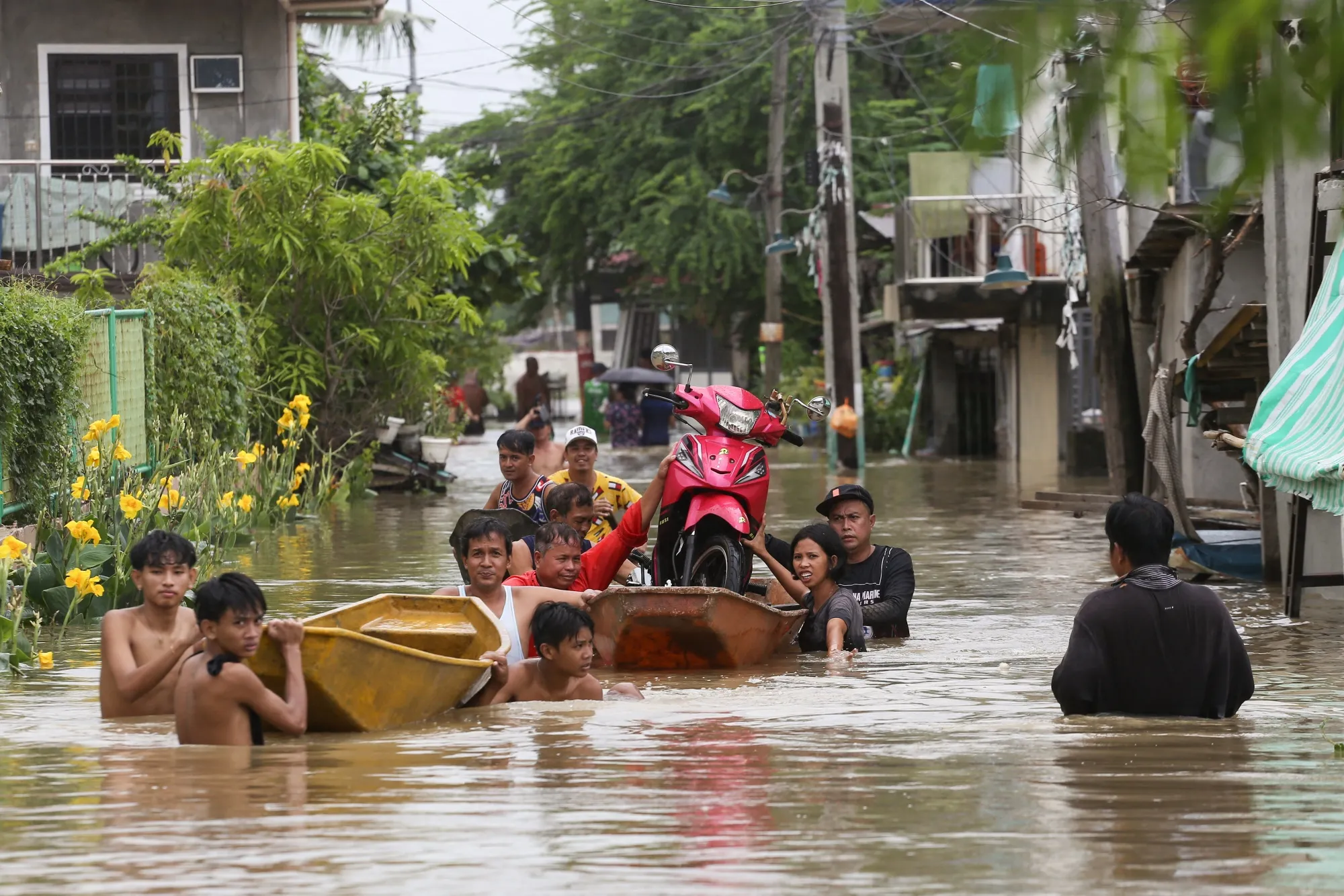 Residents transport a motorcycle on a boat to avoid floodwaters left by torrential rains of Typhoon Doksuri in the Philippines on July 29.