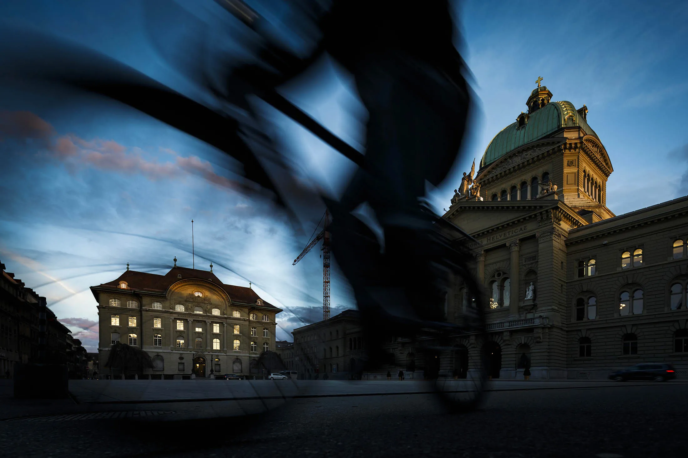A cyclist passes the Swiss National Bank (SNB), Switzerland's central bank, left, and the Federal Palace, Switzerland's parliament building in Bern, Switzerland, on Tuesday, March 12, 2013.The Swiss central bank pledged to keep up its defense of the franc cap after almost doubling its currency holdings to shield the country from the fallout caused by the euro zoneÕs crisis.
