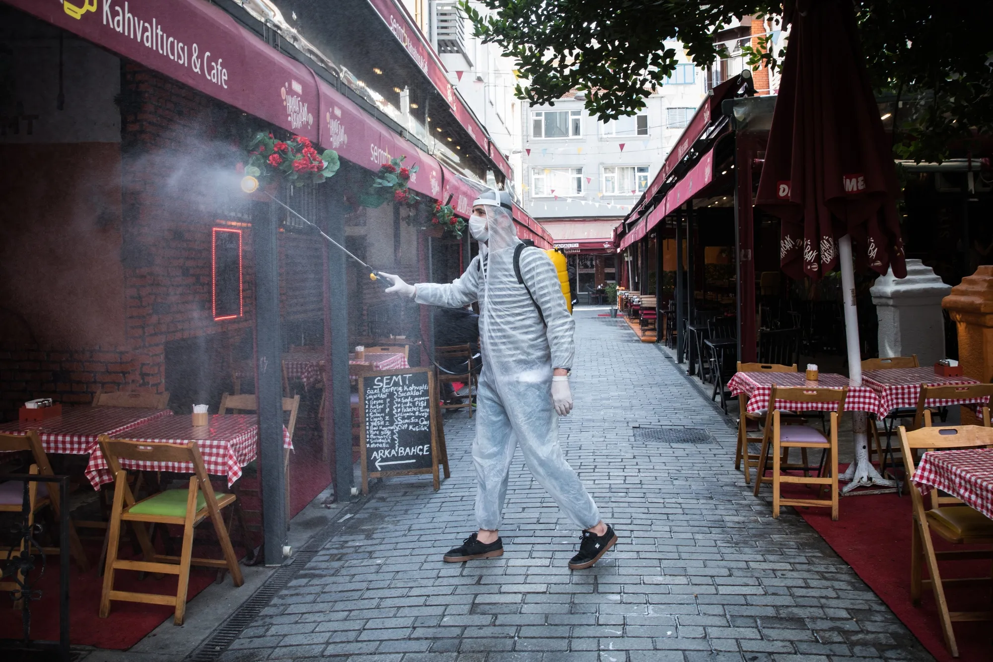 A worker sprays disinfectant around cafe tables&nbsp;following the easing of lockdown in Istanbul on June 1.