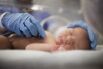 USA, Utah, Payson, Nurse listening to heartbeat of newborn in incubator