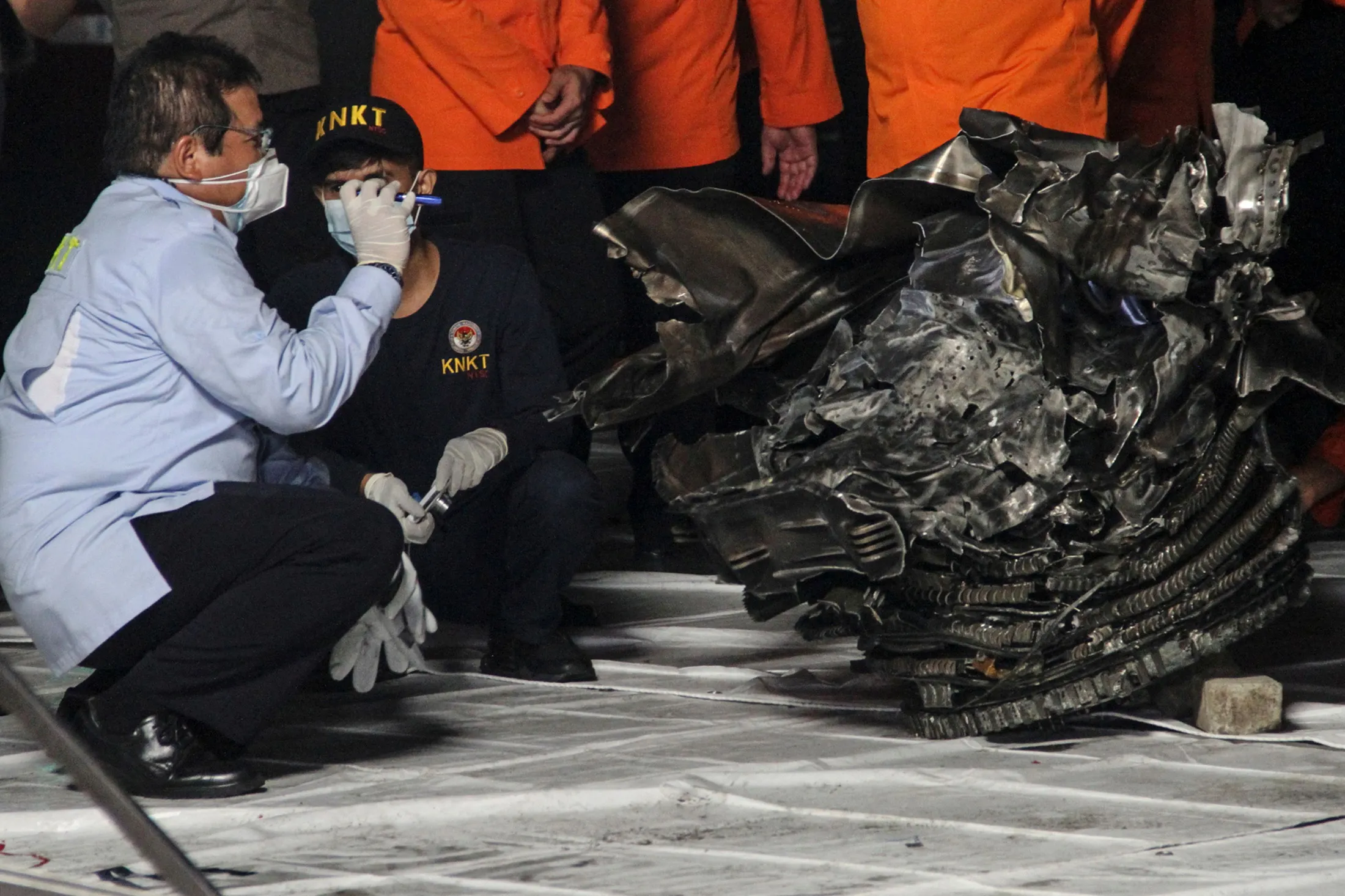 An official of the National Transportation Safety Committee&nbsp;inspects one of the engines recovered recovered from the crash site of Sriwijaya Air flight SJ182, at the port in Jakarta on Jan. 10.