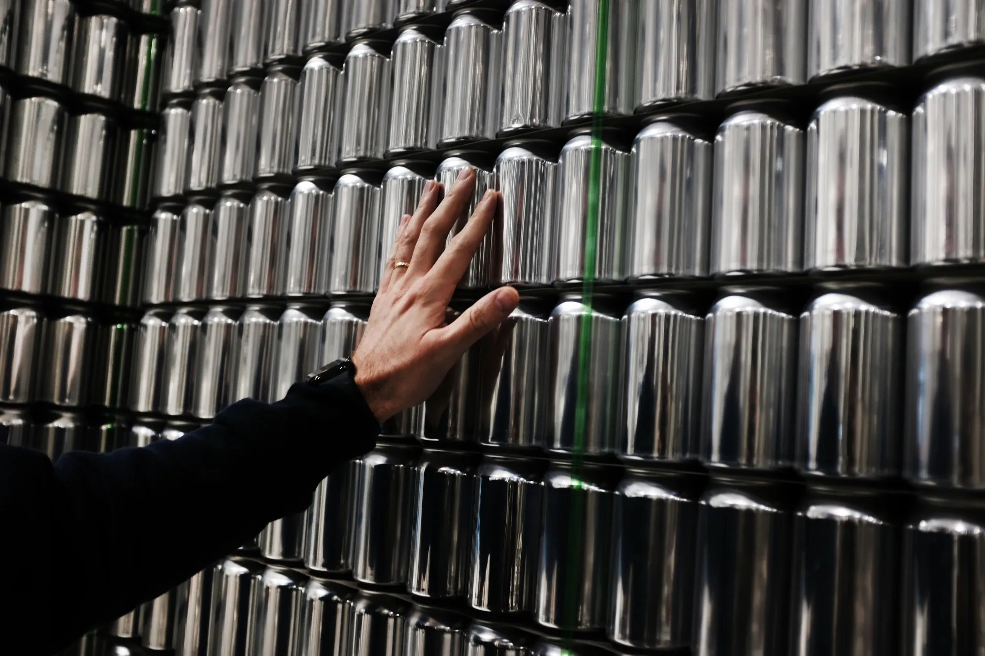 A person inspects cans at Athletic Brewing’s&nbsp;brewery and production plant in Stratford, Connecticut.&nbsp;