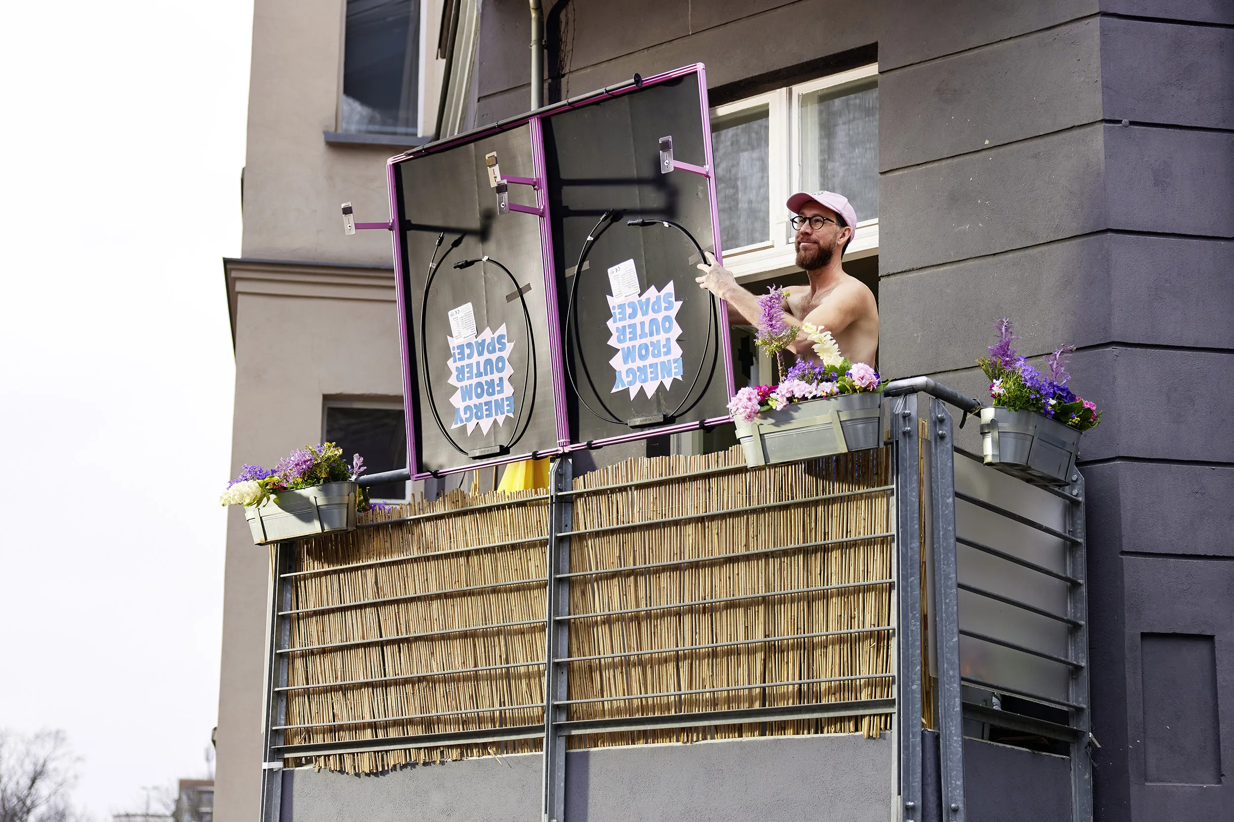 Einhorn co-founder Waldemar Zeiler hangs hangs a solar panel from an apartment balcony in Berlin.