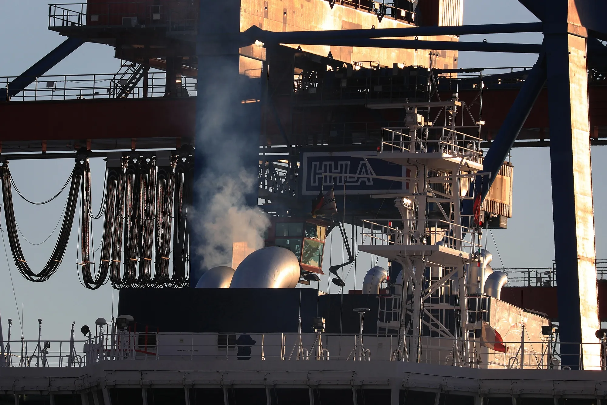 Emissions rise from the exhaust of a container vessel.