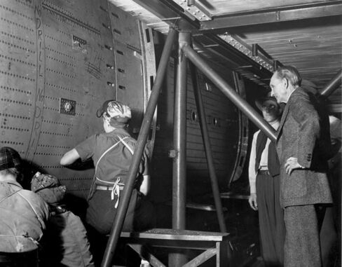 Henry Ford watching women drill and rivet the center wing section of a B-24 at the Willow Run Bomber Plant in 1942.