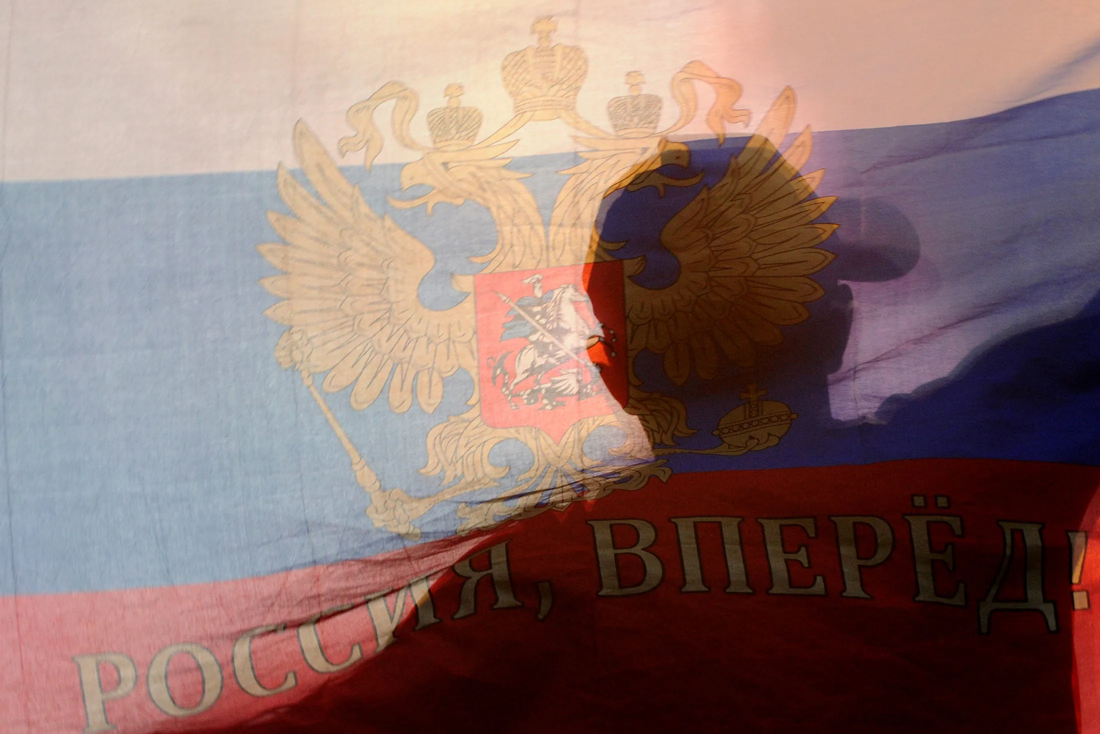 A Russian football fan watches a game on a giant screen.
