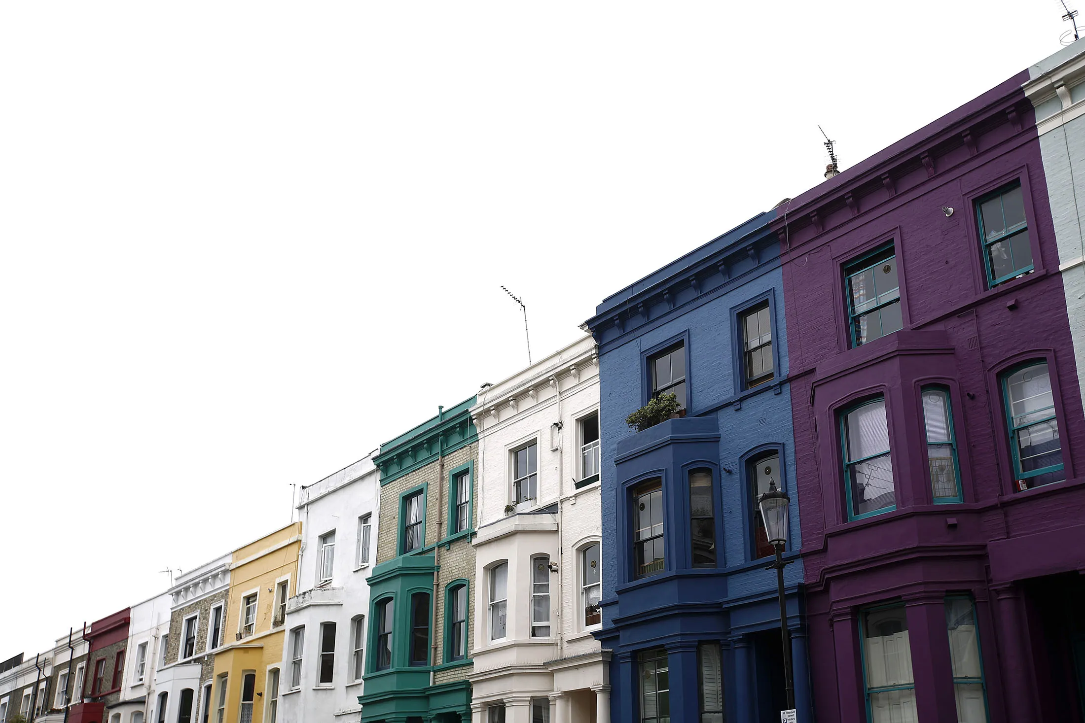 Rows of multi-colored luxury residential properties stand in the Kensington and Chelsea district of London, U.K.
