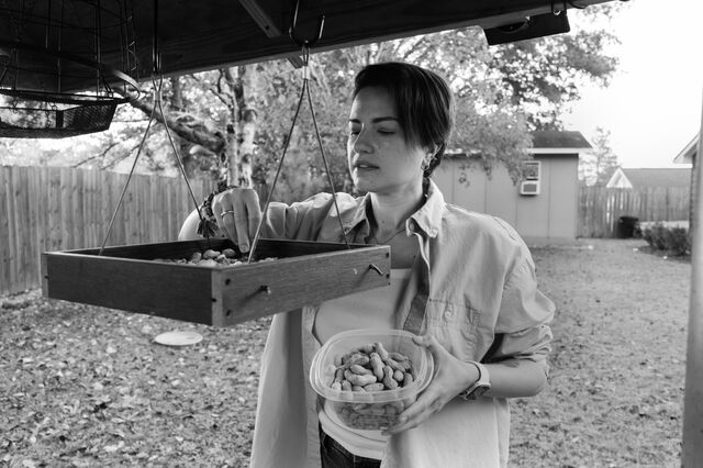 Kosareva fills a bird feeder with peanuts outside of her home.