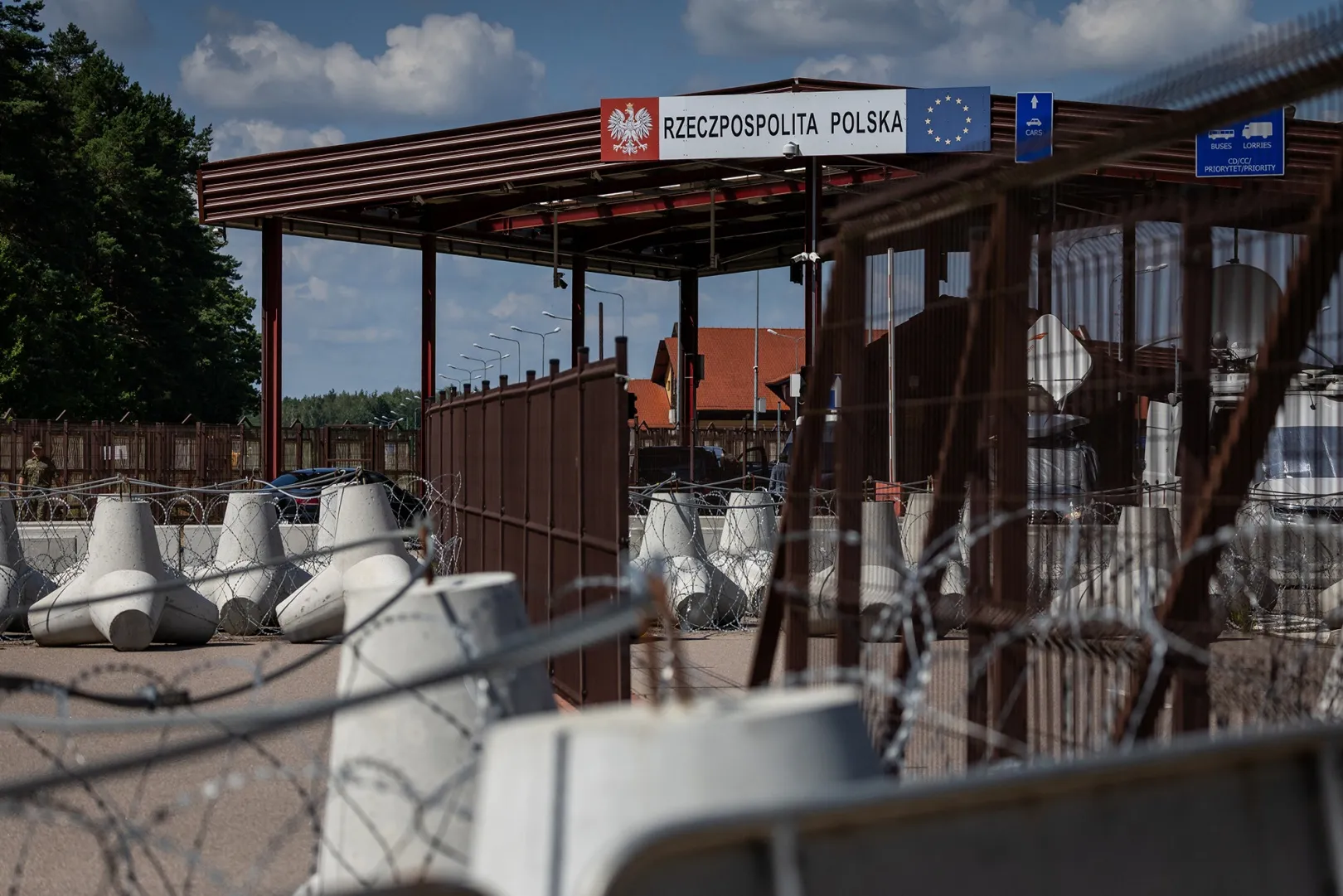 A sign reads "Republic of Poland" at the border crossing of the Polish-Belarusian country border with barbed wire and a fence in Polowce-Pieszczatka, Poland on July 21.