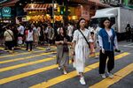Pedestrians cross a road in Hong Kong, China, on&nbsp;June 22.&nbsp;