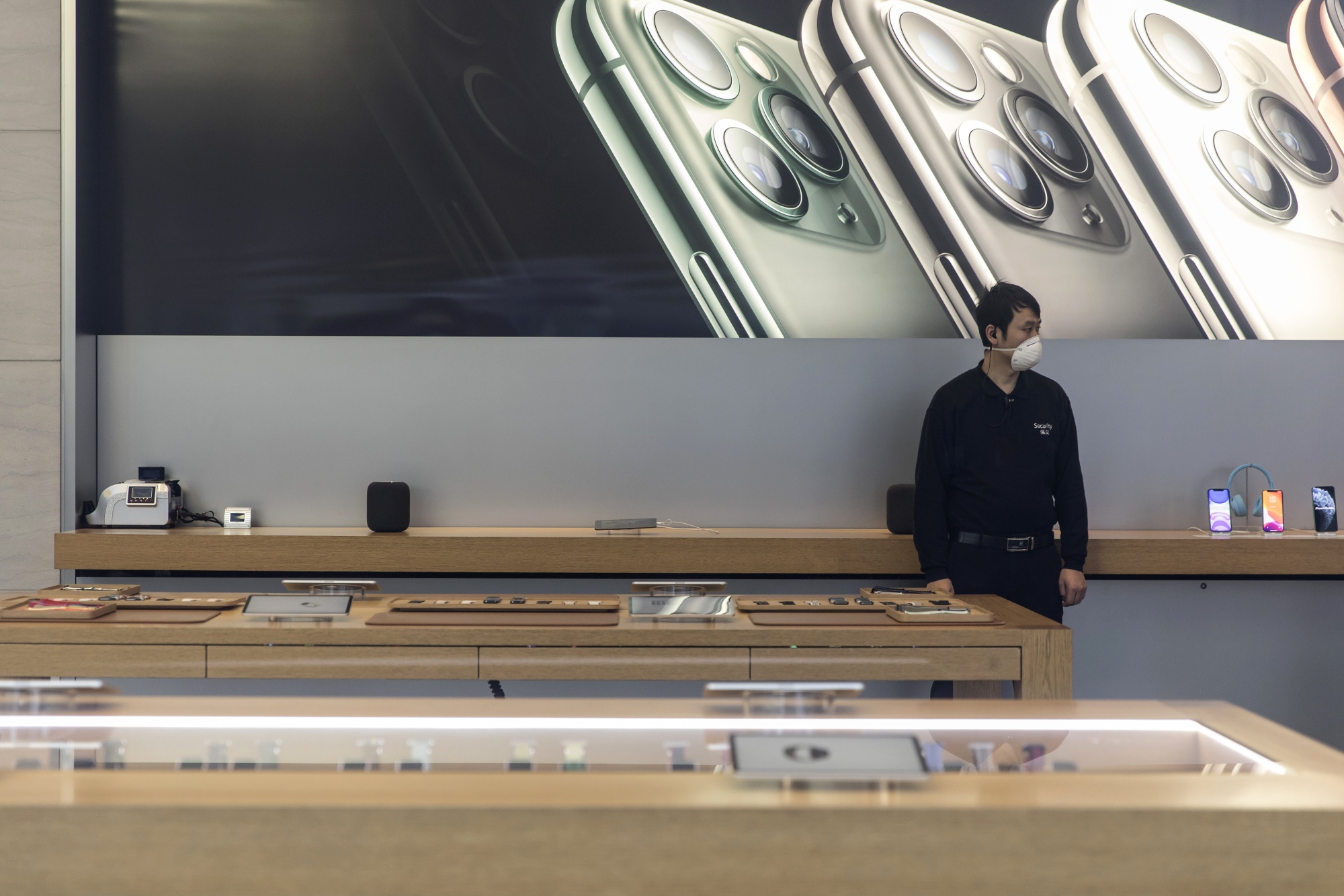 A security guard wearing a protective mask stands inside an Apple store in Shanghai.
