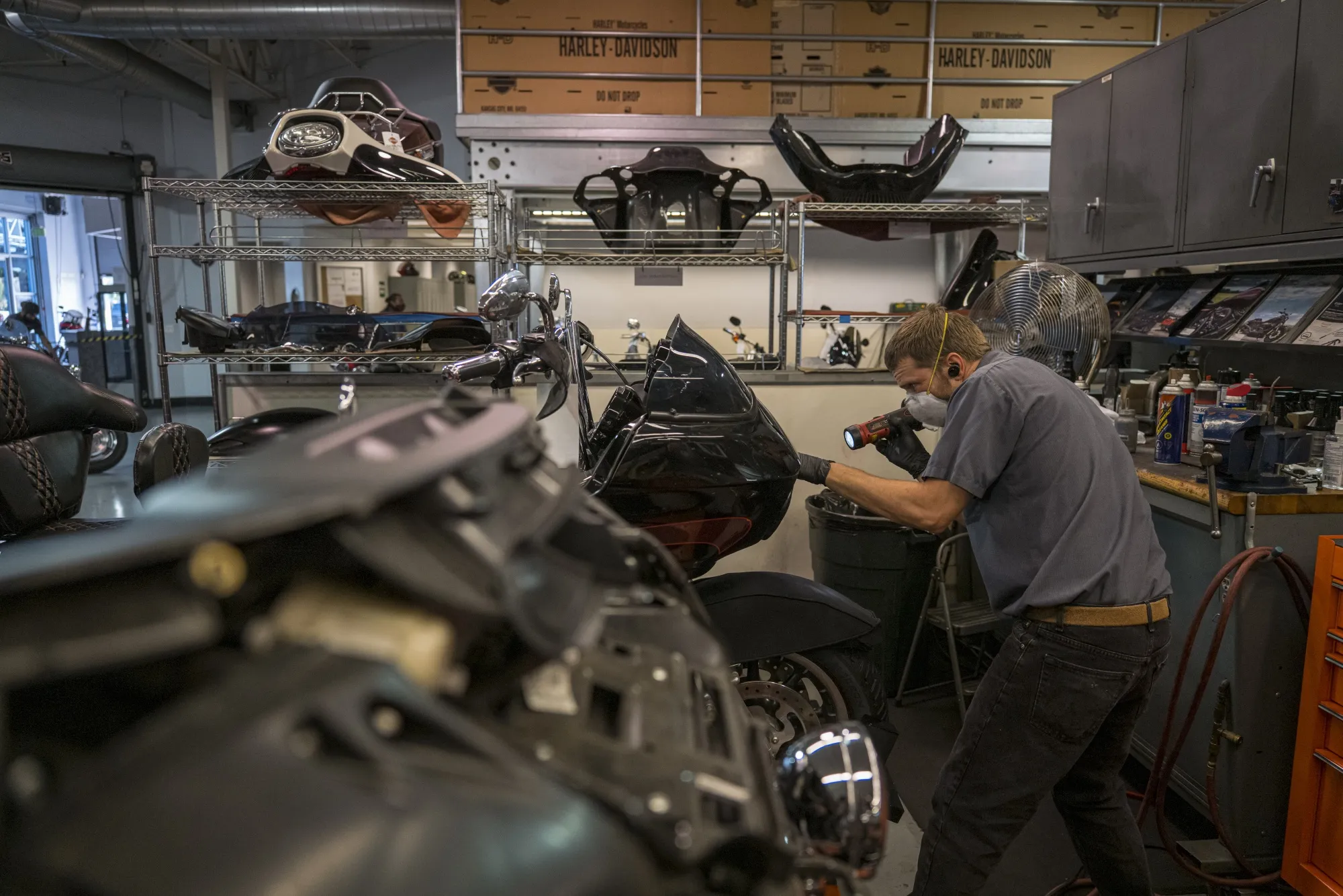 A worker repairs a motorcycle inside the service area at a dealership in Oakland, California.