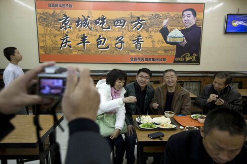 Tourists pose for photos at the Qing-Feng Steamed Dumpling Shop in Beijing on Dec. 29, 2013, a day after Xi Jinping dropped in unexpectedly and ordered a simple lunch meal.