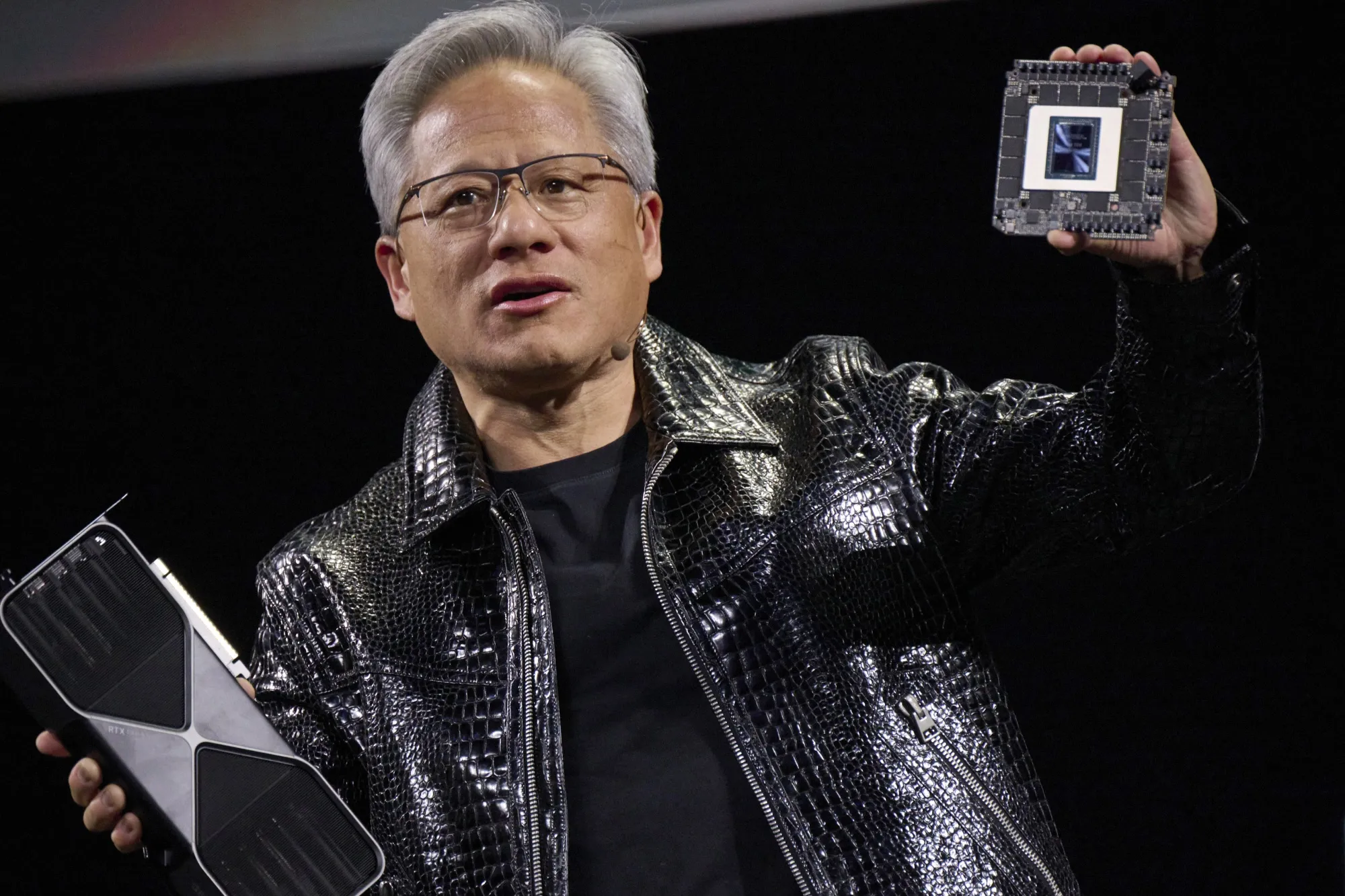 Jensen Huang woth Nvidia's new GeForce RTX 50 series graphics cards and a Thor Blackwell robotics processor.