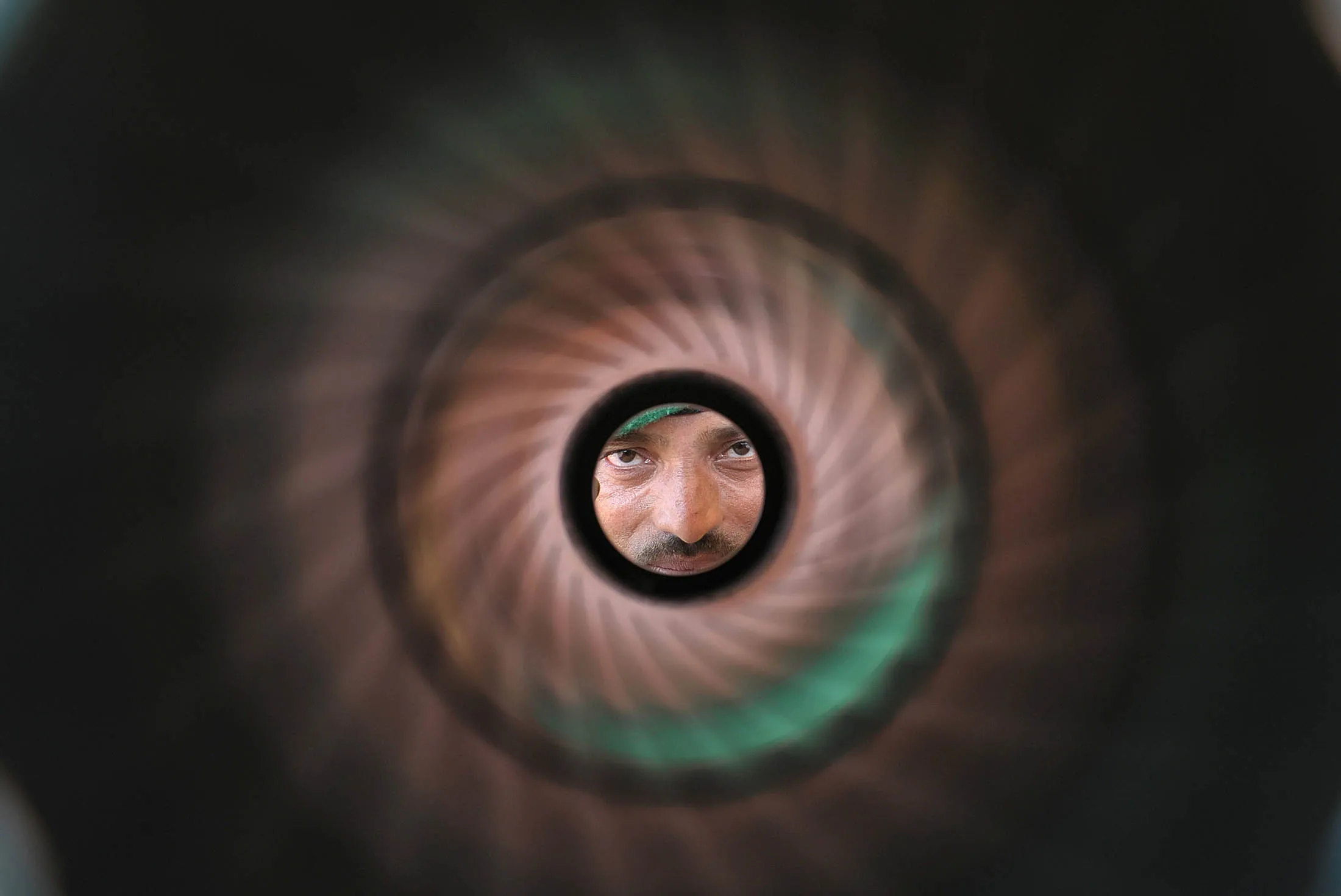 An Indian Army personnel looks through the barrel of a rocket launcher.
