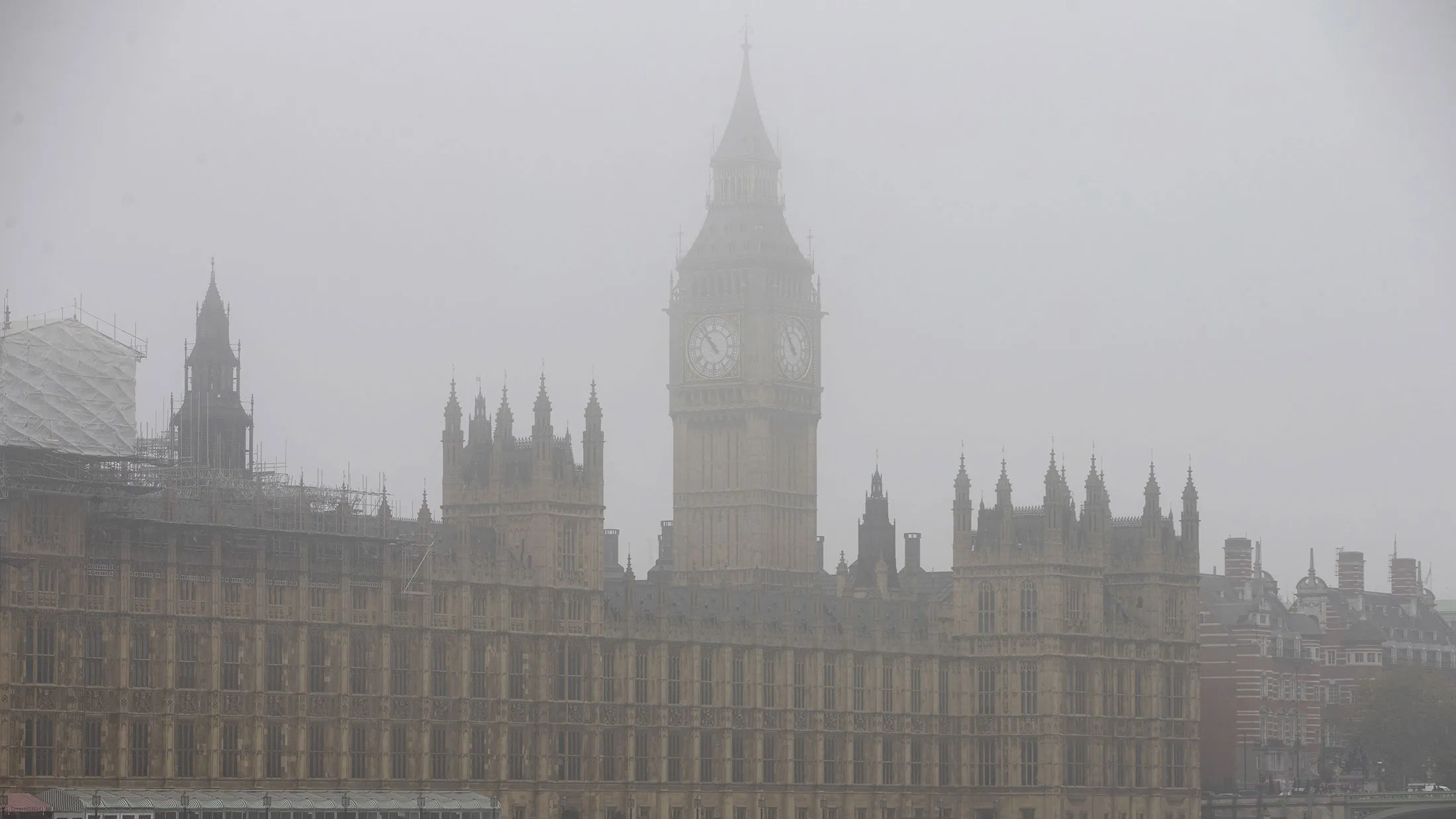 A boat travels along the River Thames through the fog past the Houses of Parliament in central London on November 2, 2015.
