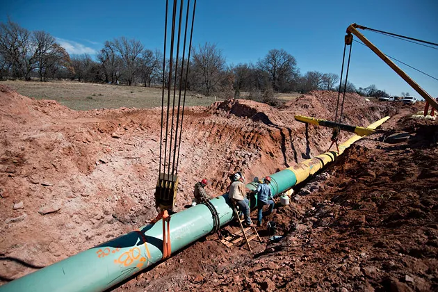 Welders work on a joint between two sections of pipe during construction of the Gulf Coast Project pipeline in Prague, Okla., on March 11