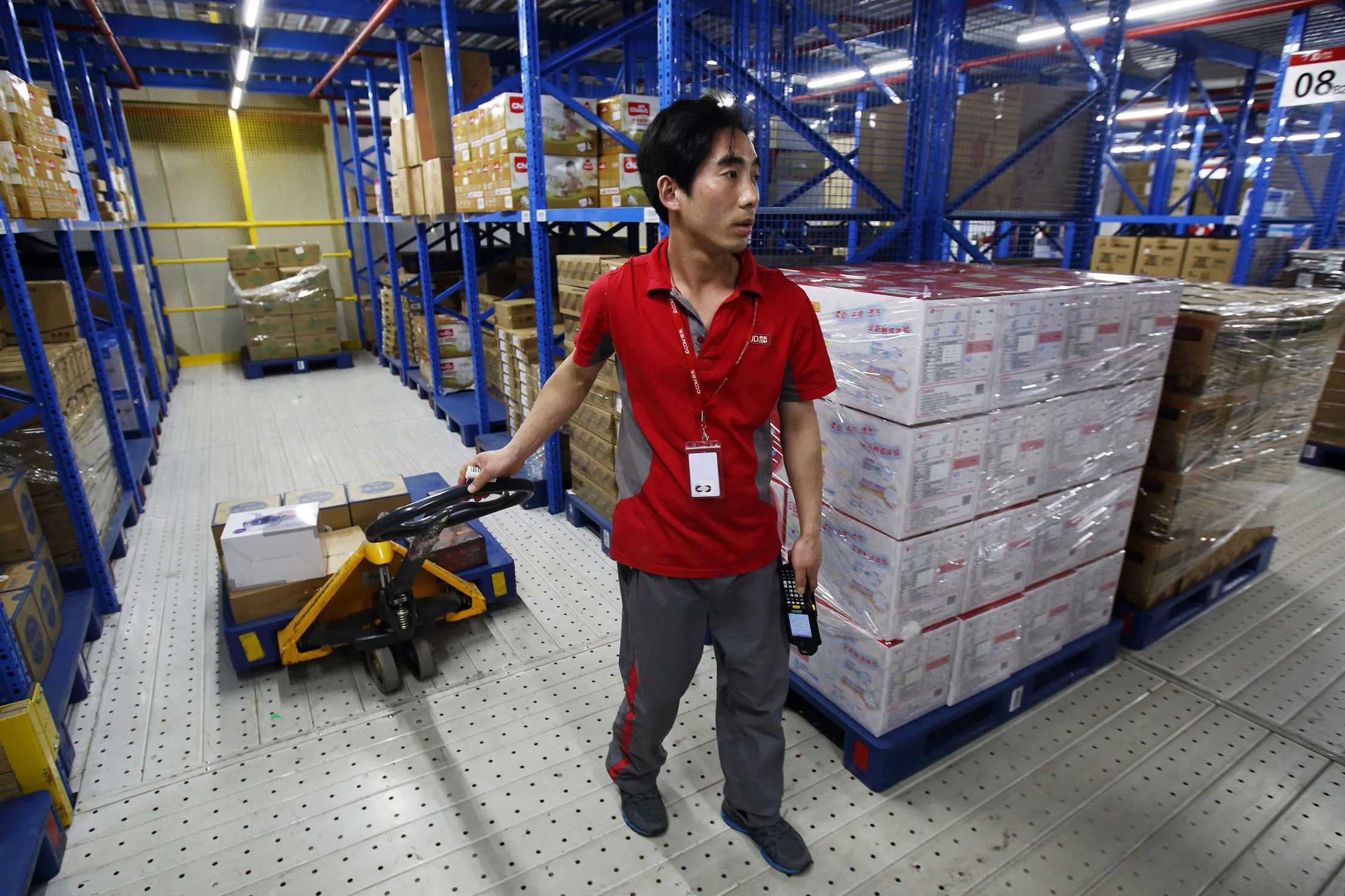A worker collecting packages pulls a trolley at a JD.com warehouse in Shanghai, China.
