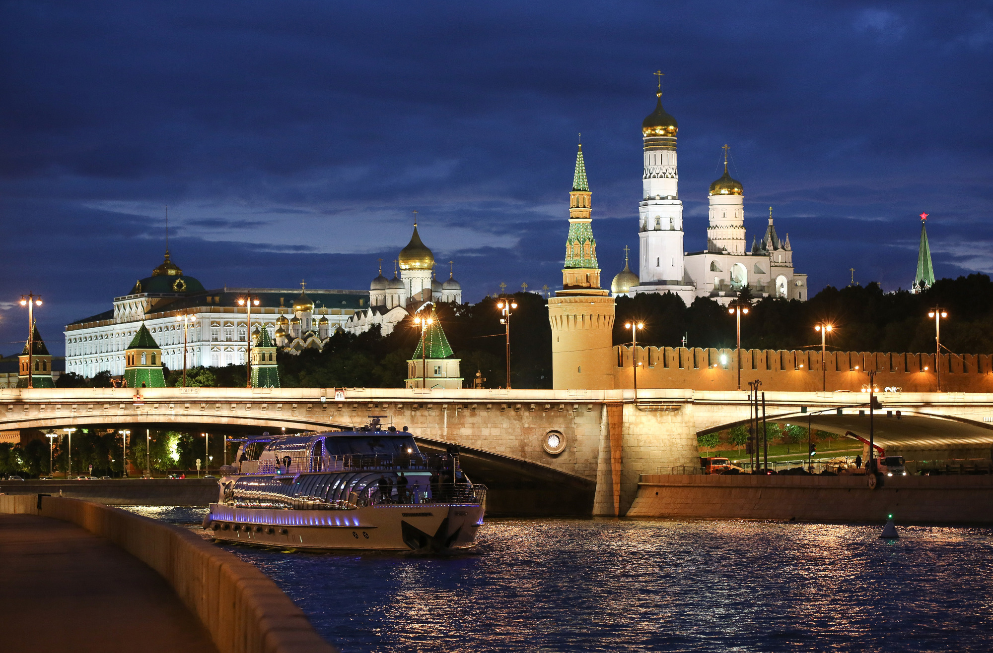 The Kremlin, right, stands illuminated on the banks of the Moscow river in Moscow.