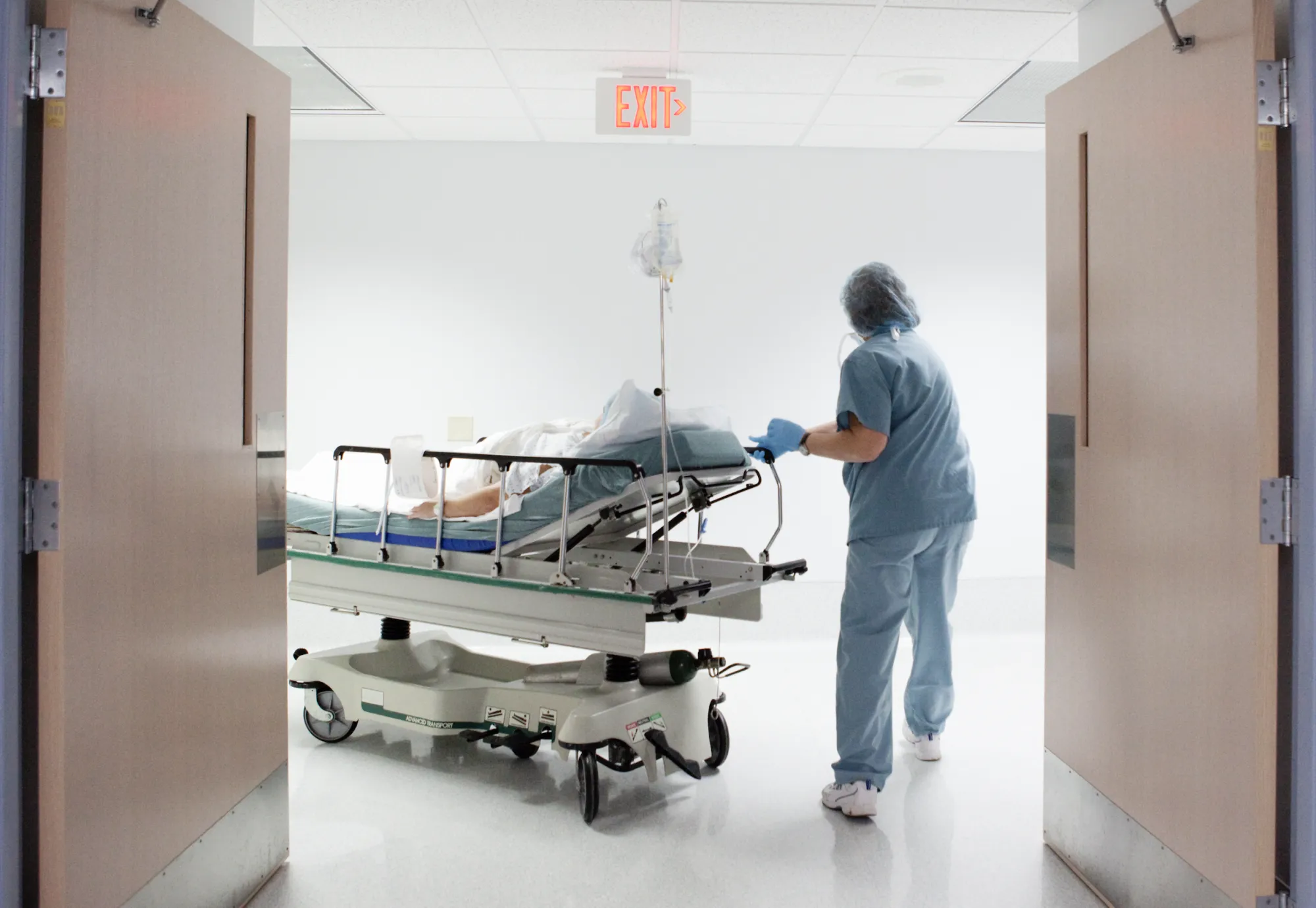 Nurse wheeling patient to surgery OR