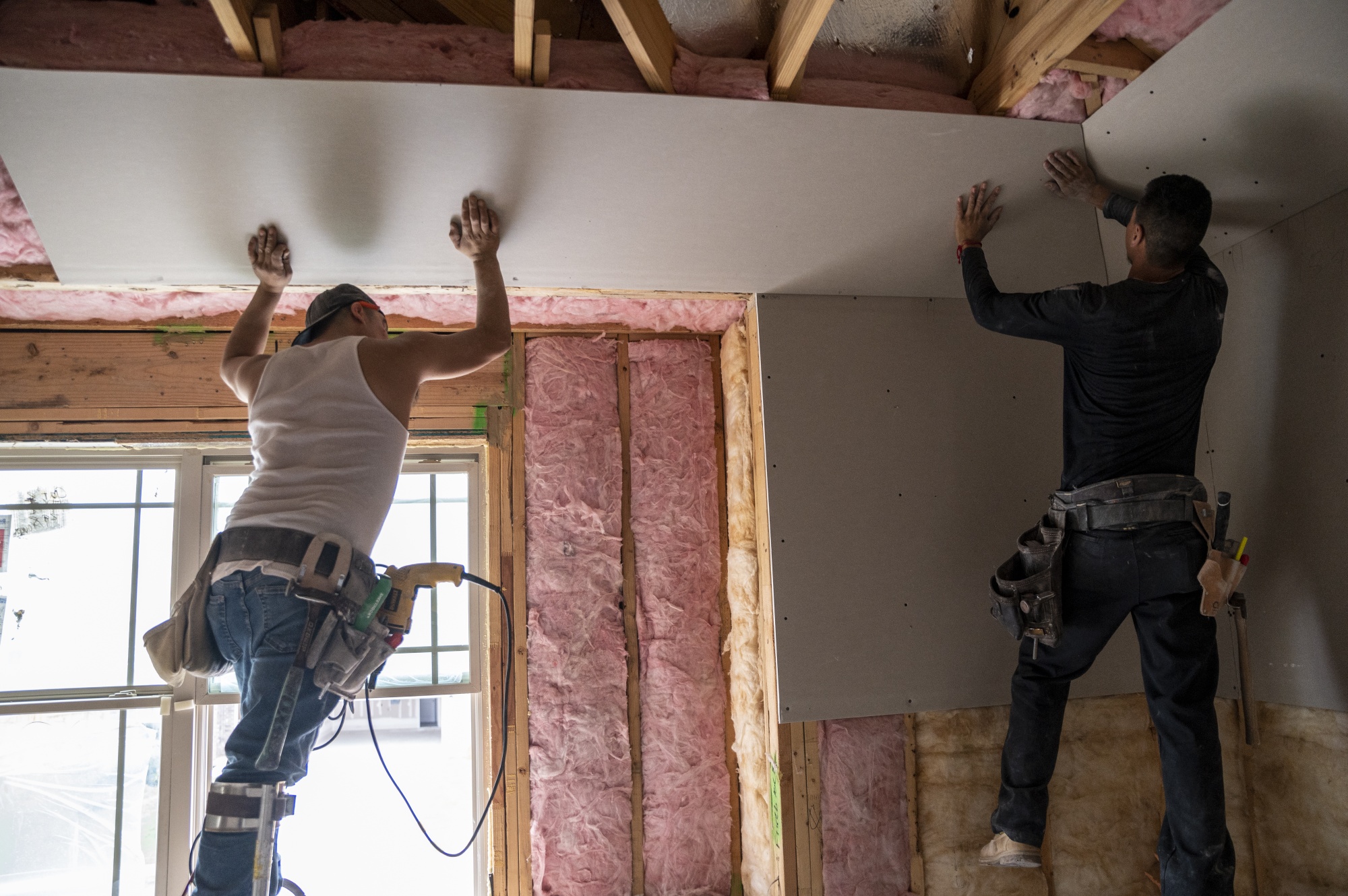 Workers cover insulation at a home under construction in Buda, Texas.&nbsp;