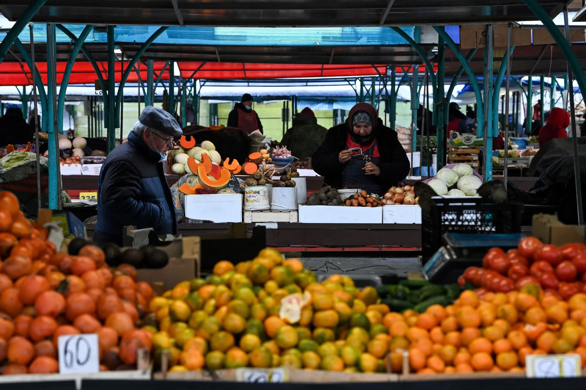 A shopper&nbsp;walks past vegetables stalls at a market in Moscow, Russia.&nbsp;
