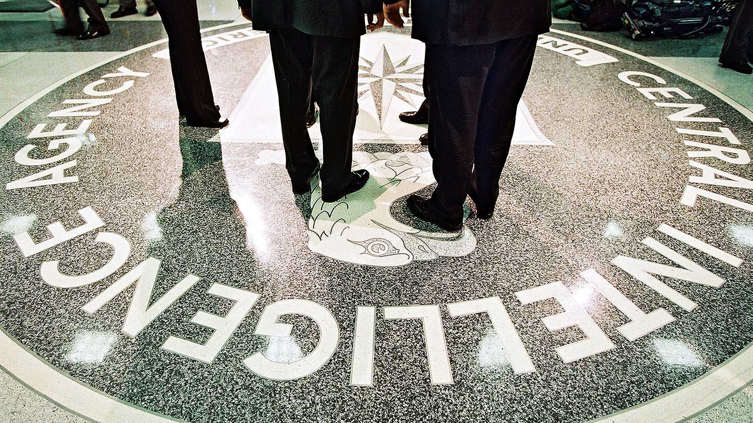 President George W. Bush, Central Intelligence Agency Director George Tenet and others stand on the seal of the Agency March 20, 2001 at the CIA Headquarters in Langley, Virginia.
