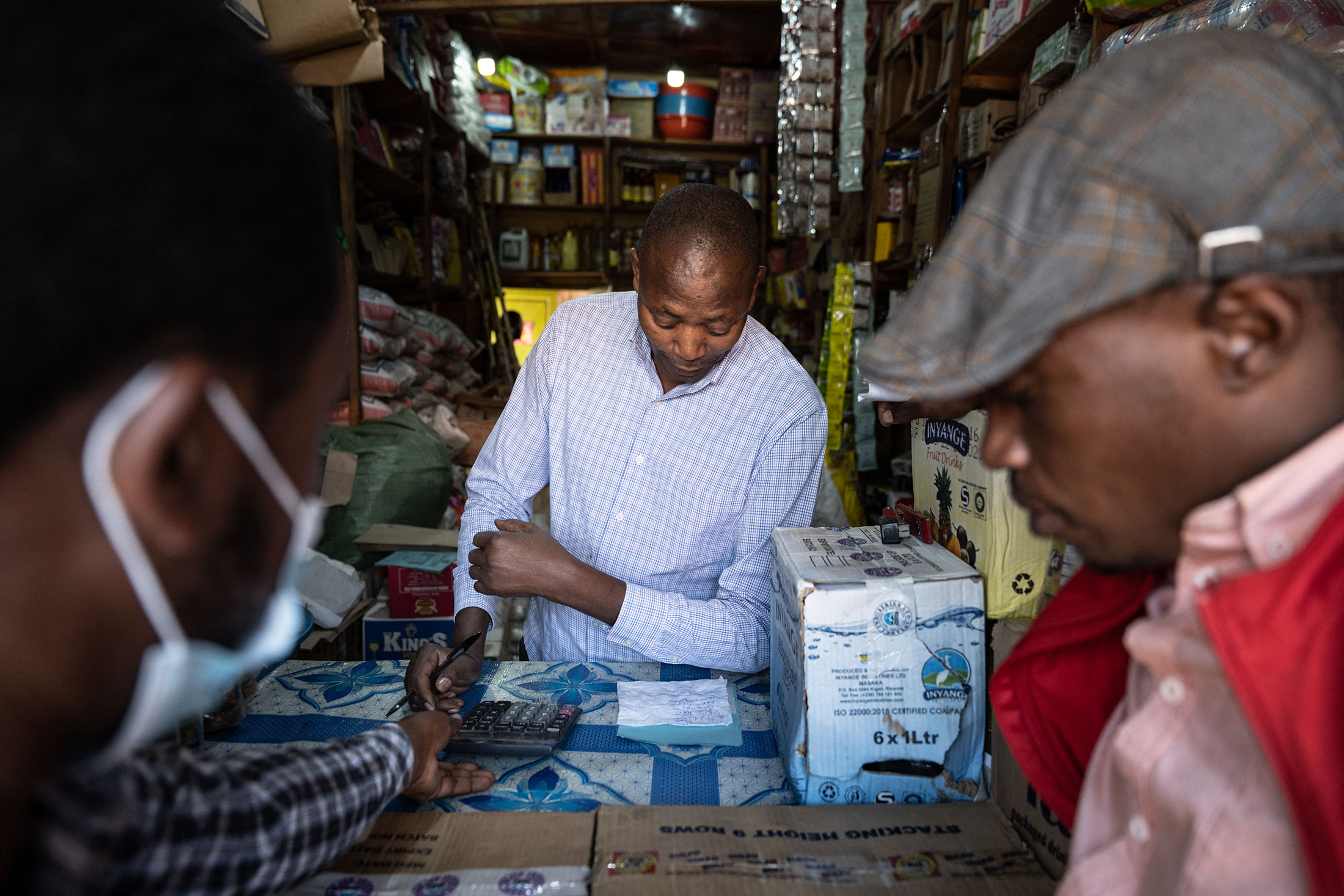 A shop owner negotiates with customers in Kigali, Rwanda, on March 23.