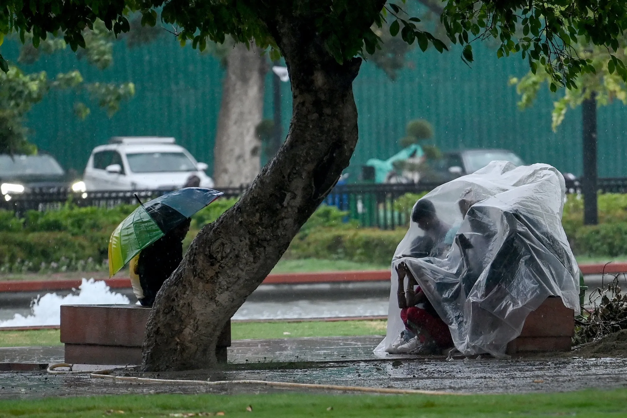 People take shelter as it rains in New Delhi on June 17.