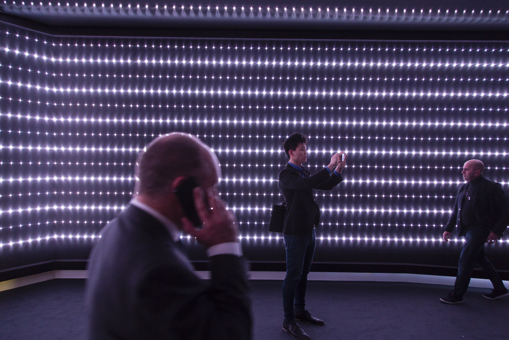 An attendee uses a smartphone to take a photo of a light-emitting diode (LED) display at the Royal Philips NV exhibition stand during the Building + Light trade fair in Frankfurt, Germany.