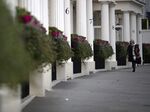 A pedestrian walks past the columned entrances to luxury residential properties in Grosvenor Crescent in London.
