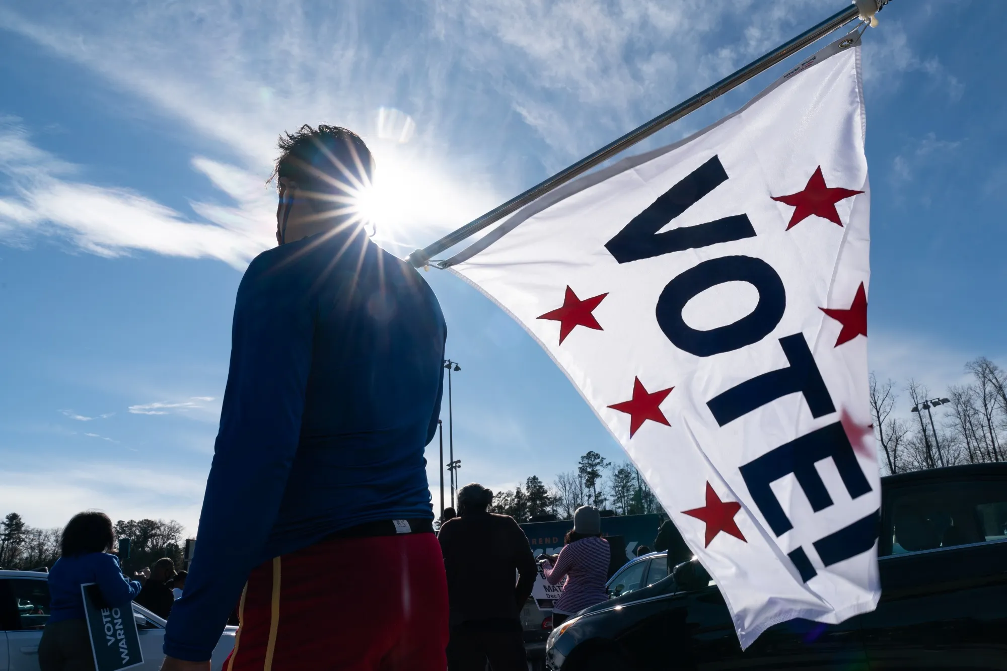 An attendee&nbsp;holds a "VOTE" flag at a campaign event for Raphael Warnock&nbsp;in Riverdale, Georgia, on&nbsp;Jan. 4, 2021.