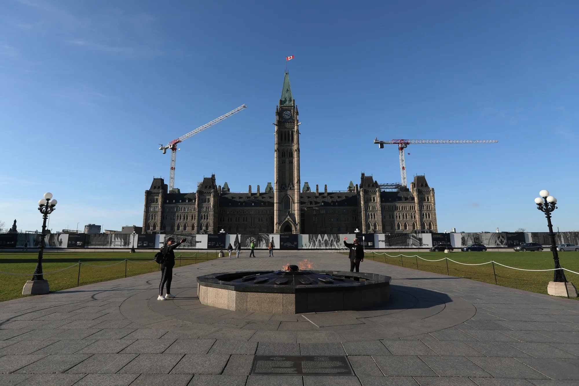 Tourists take photos in front of Parliament Hill's Centre Block in Ottawa, Ontario.